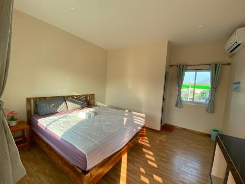 a bedroom with a bed and a window at เชียงคาน เรสติ้ง เพลส in Chiang Khan