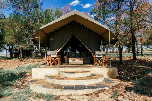 a tent with two chairs and a table in it at Cradlestone Camp in Krugersdorp