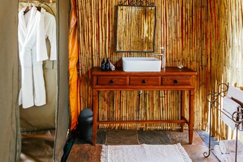 a bathroom with a sink and a mirror at Sibani Lodge - Glamping Tents in Krugersdorp