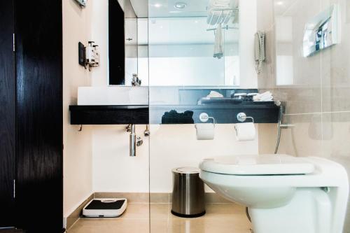 a bathroom with a white toilet and a sink at Onomo Hotel Dar es Salaam in Dar es Salaam