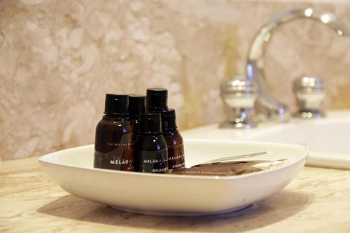 a white bowl with two bottles of soap in a bathroom at Marques Plaza Hotel in Pouso Alegre