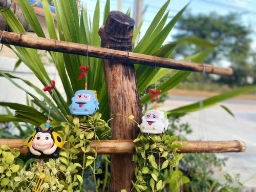 four monkey ornaments hanging from a wooden cross at เชียงคาน เรสติ้ง เพลส in Chiang Khan
