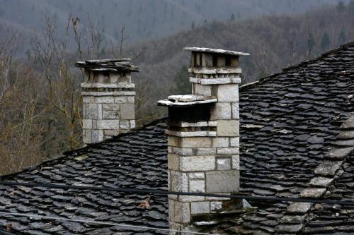 two chimneys on the roof of a house at Nikolas Guesthouse in Koukouli