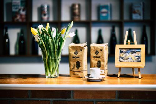 a table with a vase of flowers and a picture at Pension Gallery in Braşov