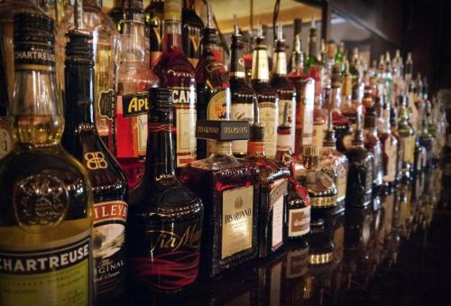a bunch of bottles of alcohol lined up on a shelf at Fort Pontchartrain Detroit, a Wyndham Hotel in Detroit