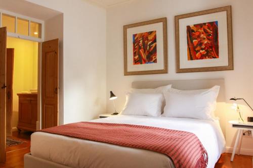 a bedroom with a large white bed with a red blanket at São Paulo Boutique Hotel - SPBH in Tavira