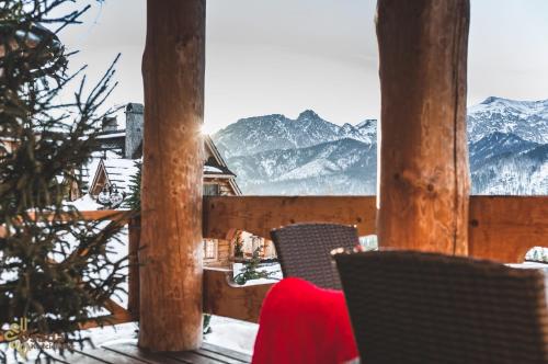 a view from the balcony of a ski lodge with snow covered mountains at Osada Kościelisko - Tatry na Wyciągnięcie Ręki in Kościelisko