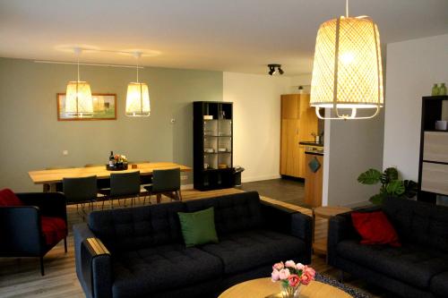 a living room with a couch and a dining room at Polderhoek in Woubrugge