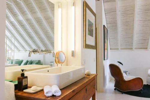 a bathroom with a large white tub and a sink at São Paulo Boutique Hotel - SPBH in Tavira