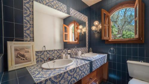 a bathroom with two sinks and a mirror at Casa Bonaire Esporles in Esporles
