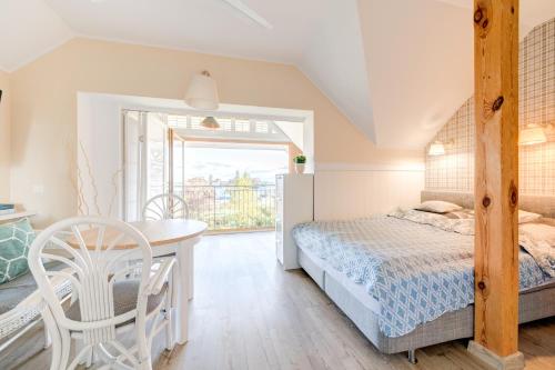 ヤスタルニャにあるVilla Pastelowaのベッドルーム1室(ベッド1台、テーブル、椅子付)