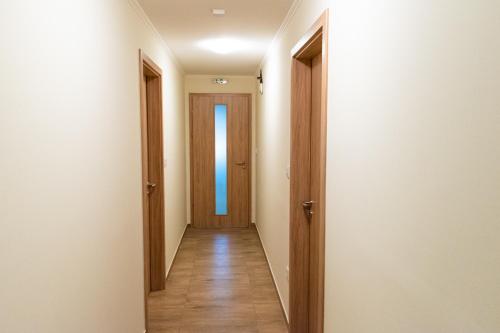 an empty corridor with a door and a hallwayngth at Randevú Panzió in Sopron