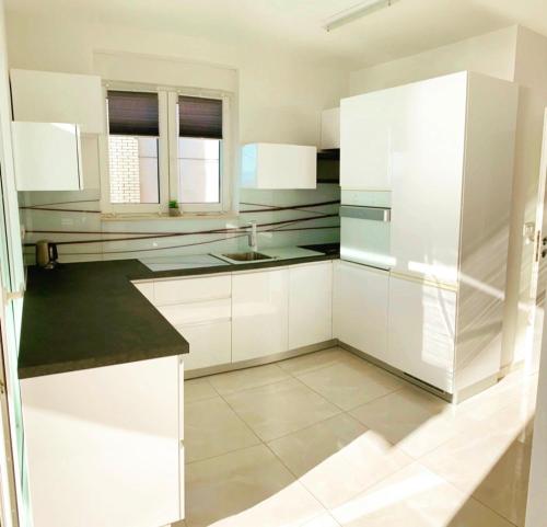 una cocina blanca con armarios blancos y fregadero en Luxury APP Anna ( near center), en Crikvenica