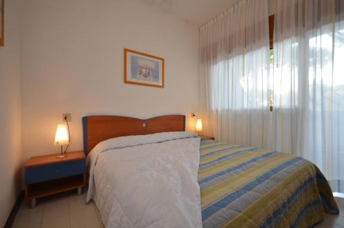 a bedroom with a bed and two lamps on a table at Villaggio Marina in Bibione