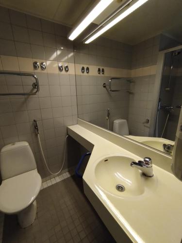 a bathroom with a sink and a toilet and a mirror at West Side Hotel in Turku