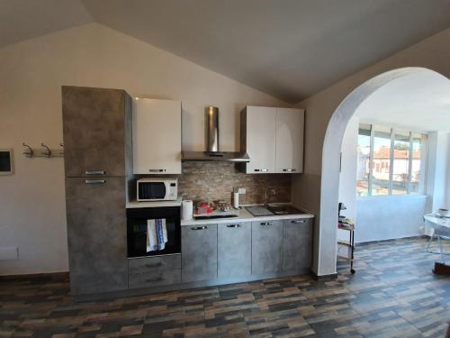 a kitchen with white cabinets and a stove top oven at C'era una volta room in Case Nuove