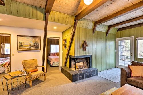 a living room with a fireplace and a bedroom at Quaint and Rustic A-Frame Less Than 5 Mi to Plumas-Eureka! in Plumas Eureka