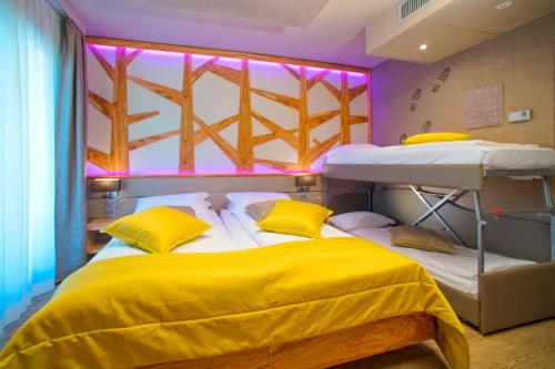 two bunk beds in a room with purple lights at Aktivhotel Santalucia in Nago-Torbole