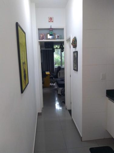 un pasillo que conduce a una sala de estar con paredes blancas en ÓTIMO Apto NA ZONA SUL DO RJ, en Río de Janeiro