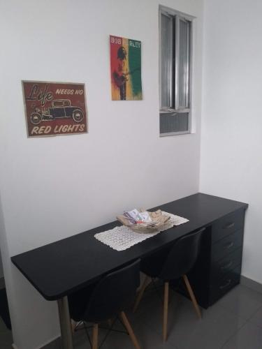 una mesa negra con 2 sillas en una habitación en ÓTIMO Apto NA ZONA SUL DO RJ, en Río de Janeiro