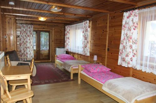 a bedroom with two beds in a wooden cabin at Dom Gościnny u Stochów in Zakopane