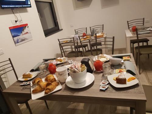 a wooden table with plates of food on it at B & B Il sorriso in Tirano