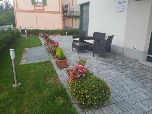 a patio with a table and chairs and flowers at B & B Il sorriso in Tirano