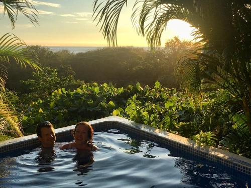 a man and a woman in a swimming pool at Horizon Hotel & Yoga Center in Santa Teresa Beach