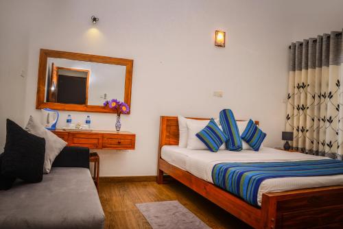 a hotel room with two beds and a mirror at Kings Villa Galle in Galle