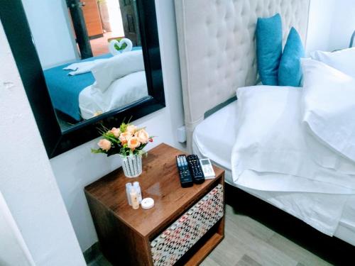 a bedroom with a mirror and a table with flowers at Santa Alejandría Hotel in Cartagena de Indias