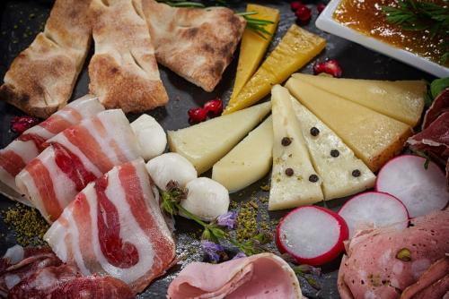 a tray of different types of cheese and meats at Rifugio Sapienza in Nicolosi