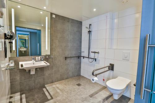 a bathroom with a toilet and a sink at Holiday Inn - Villingen - Schwenningen by IHG in Villingen-Schwenningen