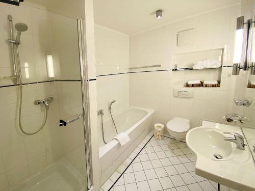 a bathroom with a shower and a toilet and a sink at Haus Kastell - Suite Strandglück in Ahlbeck