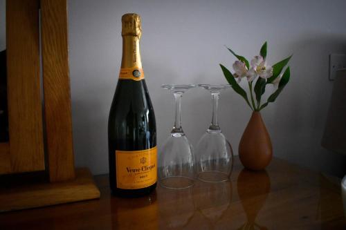 a bottle of wine and two wine glasses on a table at TLC Exmouth Bed and Breakfast in Exmouth