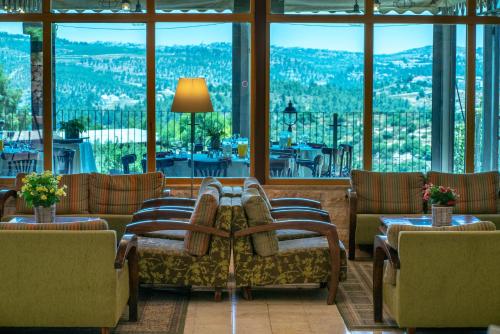 a living room with couches and a large window at Tzuba Hotel in Ẕova