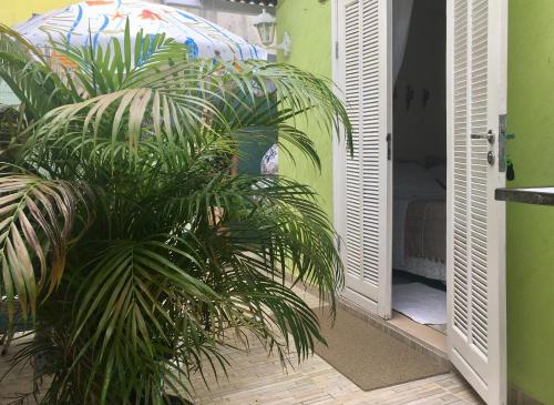 a plant in front of an open door at SUÍTES Caminho do Mar in Abraão