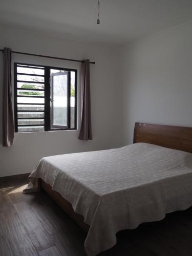 1 dormitorio con cama y ventana en Maison familiale à Ile Maurice, en Mahébourg