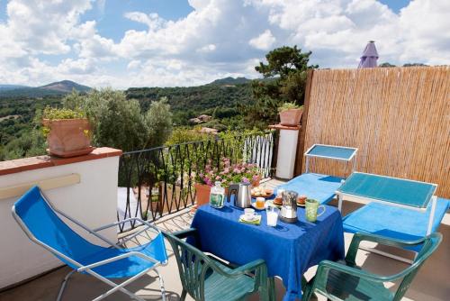 einen Tisch und Stühle auf einem Balkon mit Aussicht in der Unterkunft La Vignaredda - Residenza di Charme in Aggius