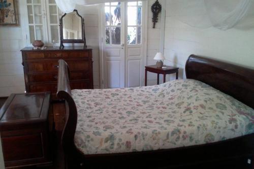 una camera da letto con un letto, un comò e uno specchio di Villa CASE LONTAN Saint Gilles les Bains a Saint-Gilles-les Bains