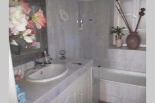 un bagno bianco con lavandino e vasca di Villa CASE LONTAN Saint Gilles les Bains a Saint-Gilles-les Bains