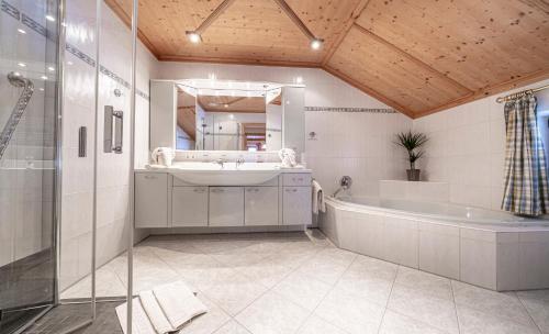 La salle de bains est pourvue d'une baignoire, d'un lavabo et d'un miroir. dans l'établissement Lamprechthof, à Lenggries