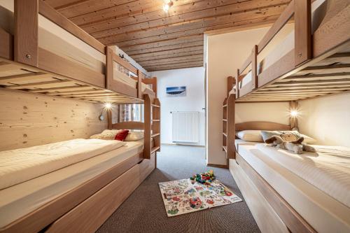 2 Etagenbetten in einem Zimmer mit Holzdecken in der Unterkunft Lamprechthof in Lenggries