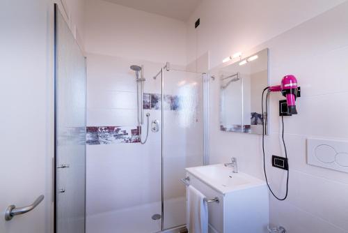 een witte badkamer met een douche en een wastafel bij Affittacamere "A2 PASSI" in Fano