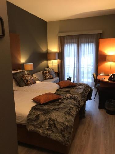 a hotel room with two beds and a desk at ´t Wapen van Marion in Oostvoorne
