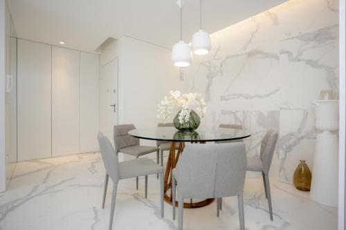 a dining room with a round table and chairs at Sea Side Luxury Apartment in Figueira da Foz