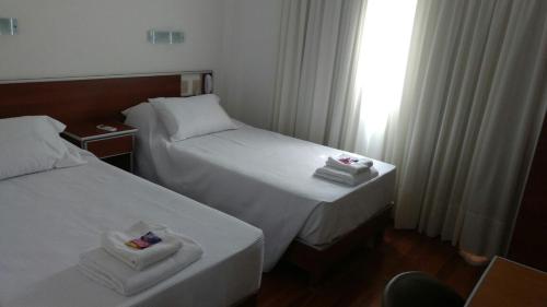 a hotel room with two beds and a window at Hotel Plaza Andalgala in Andalgalá