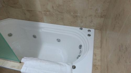 y baño con bañera y rollo de papel higiénico. en Hotel Plaza Andalgala en Andalgalá