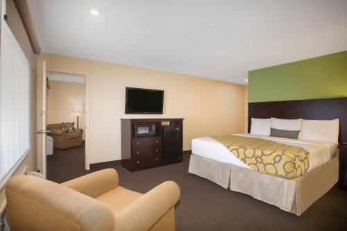 a hotel room with a bed and a tv at Baymont by Wyndham Jefferson City in Jefferson City