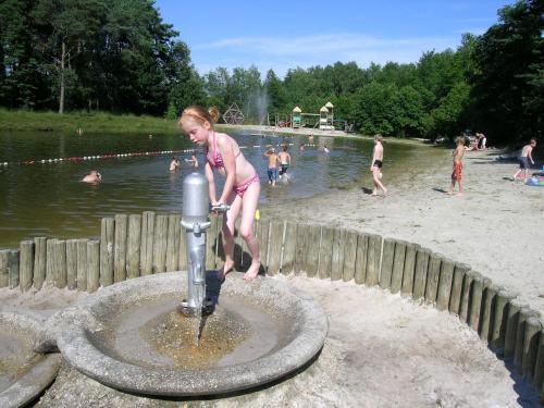 a little girl playing in a water fountain at a park at Camping Baalse Hei in Turnhout