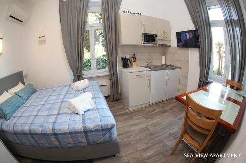 a bedroom with a bed and a table and a kitchen at Apartments Morski Svet Portorož in Portorož